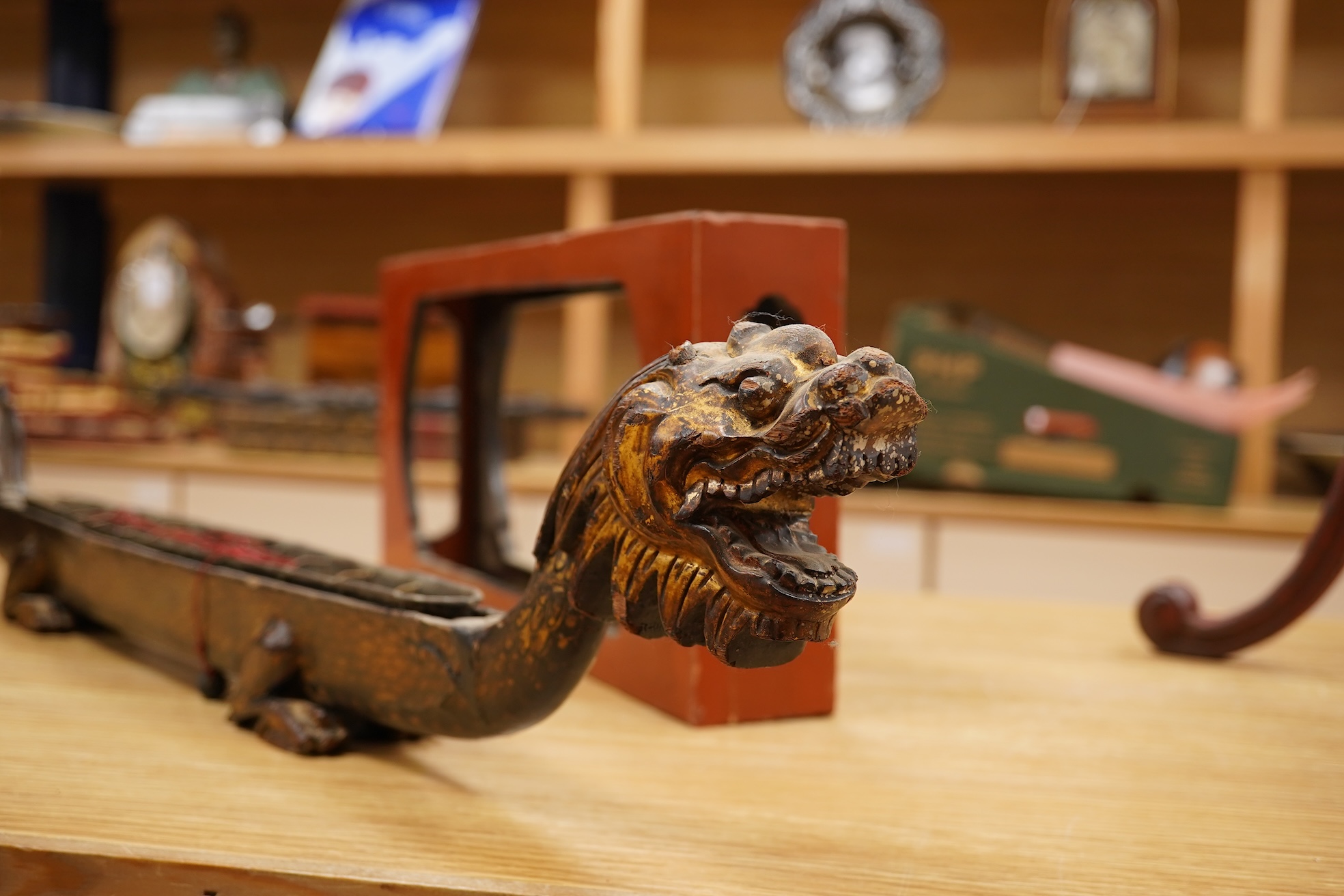 A South East Asian gilt decorated black lacquer model 'dragon' boat on stand, 75cm